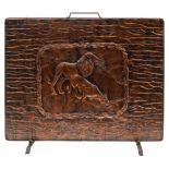 An embossed copper fire screen: of rectangular outline depicting a lion and lioness drinking at a