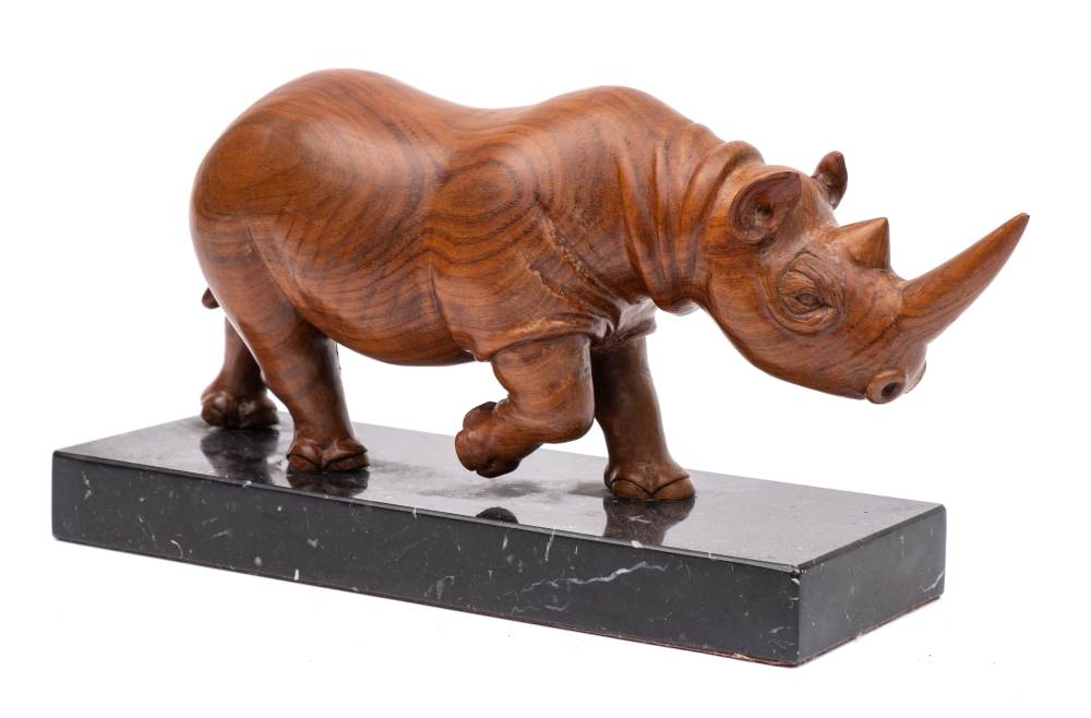 * Stan Moxom - a carved walnut figure of a rhinoceros: mounted on a polished black marble base,