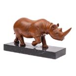* Stan Moxom - a carved walnut figure of a rhinoceros: mounted on a polished black marble base,