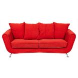 A contemporary red upholstered sofa raised on polished steel legs: