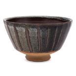 *John Leach [1939] a stoneware bowl: of footed cut-sided form decorated with oatmeal over tenmoku