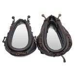 Two black leather and brass horse collar mirrors: height of largest 70cm (2).