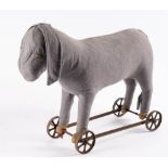 An early 20th century donkey on wheels: ( worn) together with a later blonde plush toy dog on