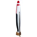 A propeller blade: painted red, white and black, mounted on a wooden socle, 184cm high,