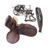 An early 20th century brown leather saddle: together with a collection of reins and tack.