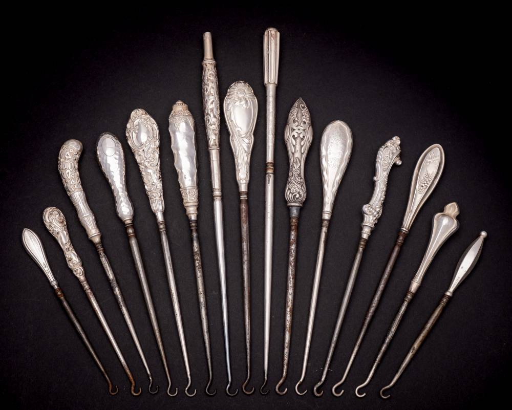 A collection of fifteen assorted silver-handled button hooks,