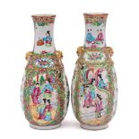 A pair of Chinese Canton famille rose vases: with relief lion-dog ring handles,