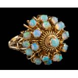 An opal dress ring,: set with a cluster of circular cut opals, stamped 18k, ring size K.