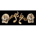 A pair of enamel and diamond skull cufflinks,: the enamel skulls with rose cut diamond set eyes,