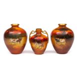 A pair of Royal Doulton vases and one smaller: the former of oviform painted with cattle in a