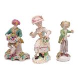 A group of three Derby figures: comprising a youth emblematic of Autumn holding a basket of fruit,