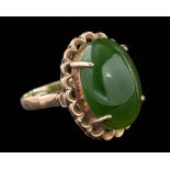 A nephrite ring,: the oval cabochon nephrite in a four claw setting, stamped 18k, ring size J 1/2.