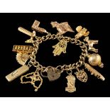 A gold coloured charm bracelet,: the curb link bracelet with various charms,