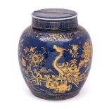 A Chinese blue ground ginger jar and cover: gilded with a large pheasant in a fenced garden with