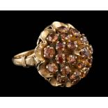 A sunstone dress ring,: set with a cluster of circular cut sunstones, stamped 18k, ring size K.