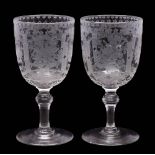 A pair of engraved glass wine goblets: each on knopped stem and engraved with panels of floral