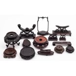 A collection of Chinese carved and plain wood stands: various shapes and sizes.