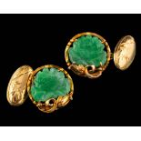 A pair of jade cufflinks,: the carved lotus jade panels within decorative surrounds, 1.7cm diameter.