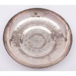 A Persian silver bowl: of beaten circular form, centered with script enclosed by a scroll border,