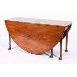 A George II mahogany gateleg dining table, circa 1740,: the oval top with twin drop leaves,