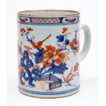 A Chinese Imari tankard: painted with a long-tailed bird perched on a peony branch in a fenced