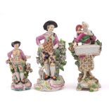 A group of three English porcelain figures: comprising a Chelsea bocage sweetmeat figure of a