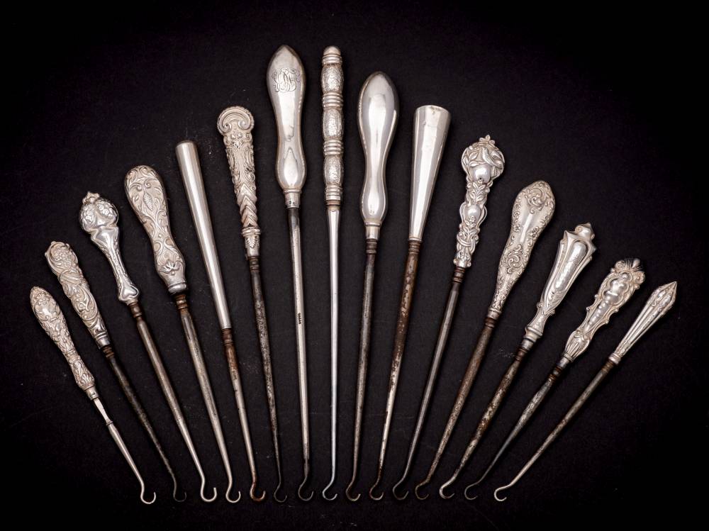 A collection of fifteen assorted silver-handled button hooks,