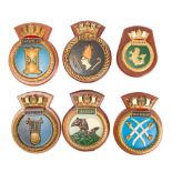 A group of nine plaster and composition Royal Navy wardroom badges: including HMS 'Astute',