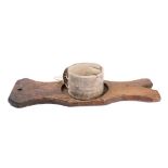 A drum-shaped cheese strainer and press:, the wooden board of shaped outline with circular recess.
