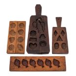 Four various treen chocolate moulds:, two with handles and one being decorated with fish.