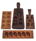 Four various treen chocolate moulds:, two with handles and one being decorated with fish.