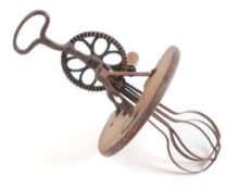 A French iron novelty whisk: with central wood platform.