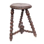 A 19th Century turned beechwood milking stool:, the circular seat with lunette foliate carved edge,