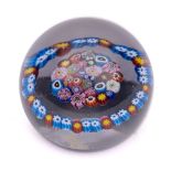 A Scottish glass paperweight: the centre with a close pack millefiori surrounded by a garland,