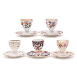 A group of five Derby egg cups on integral stands: including a Bloor 'Imari' cup,