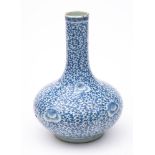 A Chinese blue and white 'peony' bottle vase: painted overall with flowering peony and dense