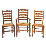 A composed set of twelve oak and rush seated ladder back dining chairs,