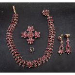 A 19th century, gold, foiled back, garnet parure of stylised flowerhead design,