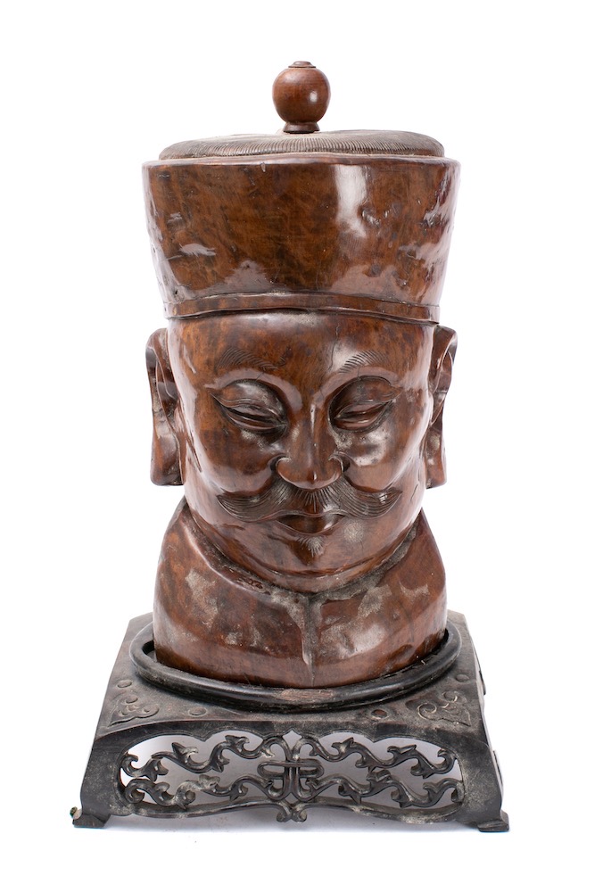 A carved wooden bust of a Chinese man: wearing a circular hat with pommel,