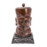 A carved wooden bust of a Chinese man: wearing a circular hat with pommel,