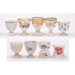 A group of seven egg cups and two egg hoops: including one in parian; one egg hoop by Minton,