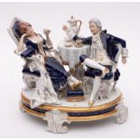 A Royal Dux Bohemia porcelain group: of a dandy and his female companion taking coffee,