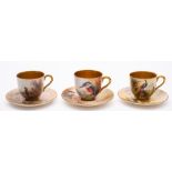 A group of six Royal Worcester porcelain coffee cups and saucers: three painted with pheasants,