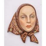 A Lenci pottery wall mask: modelled by Helen Konig Scavini as a young woman wearing a brightly