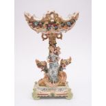 A large Continental porcelain figural centrepiece: of pierced rococo form applied with flowers and