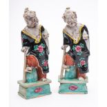 A pair of Chinese porcelain figures: of the immortal Li Tieguai stood in loose robes with one foot