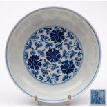 A Chinese blue and white peony saucer dish: the interior painted with a medallion of scrolling