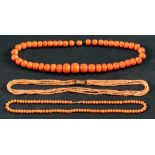 Three coral necklaces,: one single row of graduated deep pinkish orange beads, diameter ca. 8.2-14.