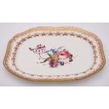 An English porcelain meat dish: of canted rectangular form and gadrooned border,