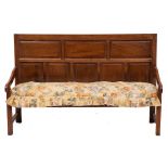 A George II oak settle, mid 18th century and later elements,: with rectangular panelled backrest,